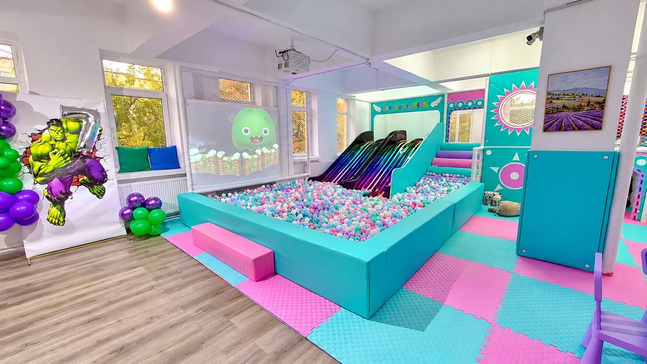Ecranul interactiv proiectat pe peretele de lângă piscina cu bile